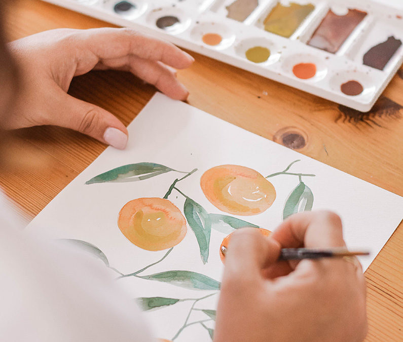 persoon schildert sinaasappels op blad